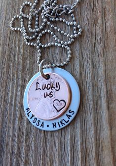 a necklace with a penny on it that says lucky us alaska and winks in the center