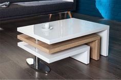 a white coffee table sitting on top of a hard wood floor next to a couch