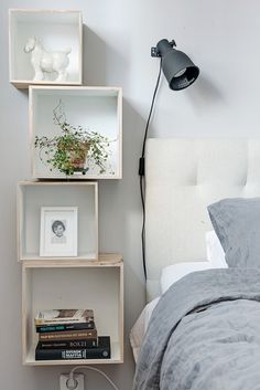 a white bed topped with two shelves filled with books