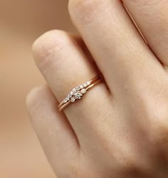 a woman's hand with a diamond ring on top of her finger, showing the side view