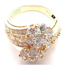 a gold ring with two rows of diamonds on it and the center surrounded by smaller round stones