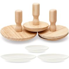 three white plates and two wooden spoons on a white background with the same design