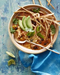 a bowl of chicken tortilla soup with beans, avocado and cilantro