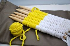 three knitting needles are laying next to each other on a piece of cloth and yarn