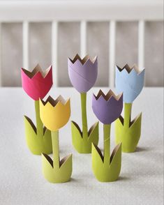 four paper tulips sitting on top of a white table