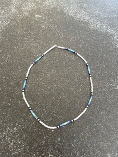 a blue and white beaded bracelet sitting on top of a table