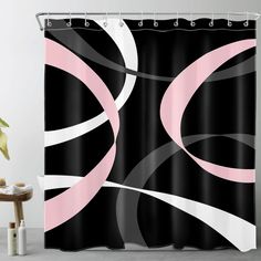 a black and white shower curtain with pink circles on the bottom, in front of a chair