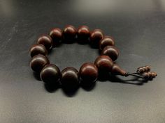 Natural Indian Red Sandalwood Bracelet, Sandalwood Bracelet, Genuine Indian Sandalwood Mala , Yoga Jewelry For Men Bracelet gift , Women Bracelet gift Size: Approx.19mm Wrist size: 6.8 inch Elastic cord bracelet  pieces of bead: 13 pieces  lock closer bead: 6 pieces of 7mm Traditional Wood Bracelets With Round Beads, Traditional Wooden Bracelets With Round Beads, Traditional Wooden Bracelet With Round Beads, Wooden Beaded Bracelets With Round Beads, Sandalwood Bracelet, Sandalwood Mala, Indian Sandalwood, Buddhist Bracelet, Red Sandalwood