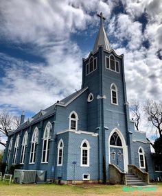 an old blue church with steeple and windows