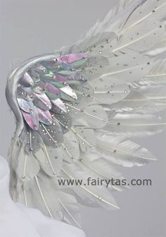 a white feather headdress with sequins and feathers on it's side