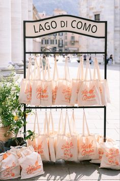 bags are on display in front of a sign that says lago di omo