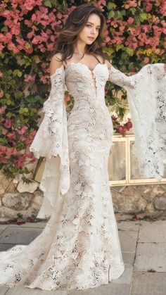 a woman in a white wedding dress standing outside