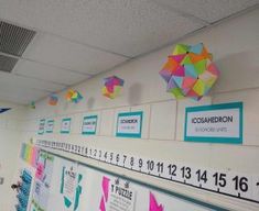 colorful bulletin boards on the wall with numbers and shapes attached to them in a school hallway