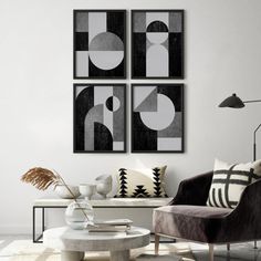 three black and white paintings hang on the wall above a coffee table in a modern living room