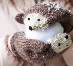 two stuffed animals are in the palm of someone's hand, with snow on them