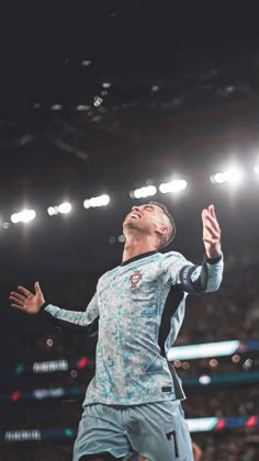 a man is jumping up in the air to catch a soccer ball with his hands