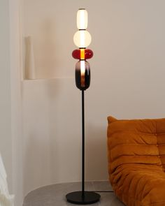 a lamp that is sitting on top of a table next to a couch in a room