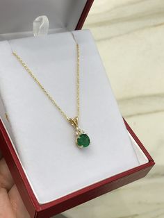 Featured here is a stunning, round natural emerald & diamond necklace in fine 14K yellow gold. Displayed is a medium-green emerald with very good transparency, accented by a simple four-prong mount allowing for the emerald to be shown in full view. The earth mined green emerald has a desirable rich green color with excellent qualities. Three diamond accents are placed on top of the emerald! This pendant is ideal for everyday use and is the perfect accessory to any outfit. This pendant comes Fine Jewelry Emerald Necklaces With Diamond Accents, Exquisite Round Green Emerald Necklace, Green Round Gemstone Diamond Necklace, Exquisite Diamond Necklace With Emerald, Exquisite Round Emerald Diamond Necklace, Classic Green Diamond Pendant Necklace, Green Pendant Diamond Necklace In Classic Style, Classic Green Pendant Diamond Necklace, Fine Jewelry Green Necklace With Diamond Accents