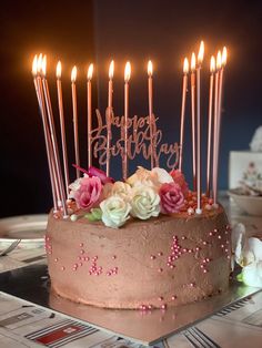 a birthday cake with candles and flowers on it