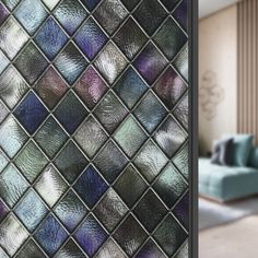 an image of a living room with blue couches and glass tiles on the wall