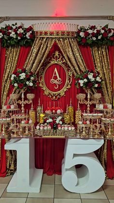 the table is set up with gold and red decorations for an elegant wedding or special event