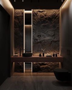 a modern bathroom with stone walls and lights on the ceiling, along with two sinks