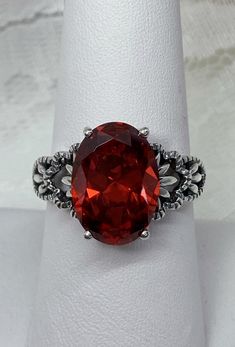 "Red Garnet CZ Ring Ace-Oval Design#92 Custom Made I now offer this lovely Gothic/Renaissance inspired ring in sterling silver. This gorgeous ring is set with a flawless Red Garnet Cubic Zirconia gemstone. The full cut 5ct oval cut gemstone is 14mm (9/16th of an inch) Long by 10mm Wide (3/8th\"). The ring sits 7mm off the finger. The inside of the band Is marked 925 for sterling. Notice the beautiful leaf-like design of the filigree setting. A ring box is included for safe keeping. Feel free to Formal Oval Ruby Ring With Stone Setting, Victorian Red Oval Filigree Ring, Oval Filigree Ring With Accent Stones For Formal Occasions, Formal Oval Rings With Stone Setting, Formal Oval Ring With Stone Setting, Classic Oval Ruby Ring With Gemstone Accents, Oval Rings With Stone Setting For Formal Occasions, Oval Ruby Ring With Stone Setting, Red Oval Filigree Ring For Anniversary