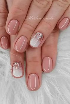 french manies with white and gold designs on the tip of each nail, which is accented with glitter