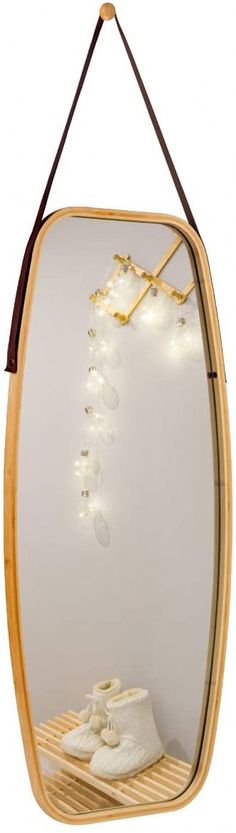 a mirror that has some shoes hanging on the front and side of it with string lights