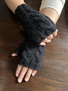 Pair of lovely hand-knitted fingerless mittens/gloves in a nice black with purple metallic color. It is made using double thread 60% Wool, 1% metallic, and 39% Acrylic. These lovely soft mittens/gloves are a great way to keep your hands and wrists warm while keeping your fingers free! It is ideal for keeping nice and warm either outdoors or indoors. They are made of a double thread which makes them very warm. Wash 30oC, hand wash. Dry flat. Do not Iron. This item comes from a smoke and pet-free Winter Fitted Cable Knit Pattern, Cozy Black Knitting Pattern For Winter, Cozy Black Winter Knitting Pattern, Black Hand Knitted Knitting Pattern, Cozy Black Hand Knitted Pattern, Black Hand Knitted Pattern, Winter Hand Knitted Black Knitting Pattern, Winter Cable Knit Pattern One Size, Winter Black Knitting Pattern