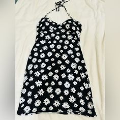 This Previously Loved Tie Up Black And White Tie Up Flower Dress Is Form Fitting, It Is Made Up Of 62% Polyester, 30% Recycled Polyester, And 8% Spandex. It Ties Up In The Back And Has Padding In The Bust. It Is Perfect To Wear At The Beach Or On A Hot Day. This Has Never Been Worn Just Sitting In My Closet! Fitted Daisy Print Mini Dress For Spring, Spring Black Printed Sundress, Fitted Mini Dress With Daisy Print For Spring, Black Printed Sundress For Spring, Fitted Daisy Print Summer Dresses, Fitted Daisy Print Beach Dress, Fitted Daisy Print Floral Dress For Spring, Fitted Black Dress With Daisy Print, Fitted Daisy Print Mini Dress For Beach