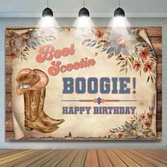 an old western birthday card with boots and flowers on the front, hanging from three spotlights