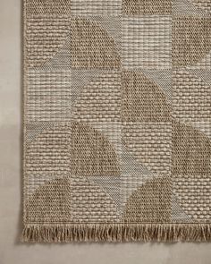 an area rug with woven squares and fringes