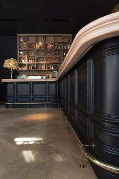 an empty room with black walls and gold trim around the bar area is pictured in this image