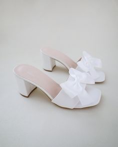 "Classic satin slip on block heel sandals for casual and dressy look. Style with satin bow at the front that adds a romantic touch, or without the bow for a classy simple style. Comfortable and easy wear for bridal wear, bridesmaids, holiday party, wedding parties, and any special occasions.  DETAILS: HEEL HEIGHT: 2.5 Inches COLORS AVAILABLE: Ivory and White UPPER: Synthetic upper and lining MATERIALS: Manmade outsole STYLE NAME: VERONA Not sure of which size to purchase? Shoes measurements are Bridesmaids Sandals, Block Heels Wedding, Bridesmaid Sandals, Sandals With Bow, Sandals Wedding, Short Heels, Bridal Sandals, Fancy Shoes, Cute Heels