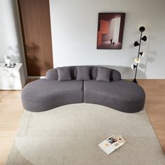 a large gray couch sitting on top of a wooden floor next to a white rug