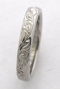 a wedding ring with an intricate design on the outside and inside, sitting on a white surface