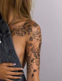 a woman with tattoos on her arm and shoulder is holding an old pair of jeans