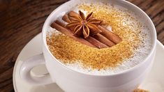 a cup of coffee with cinnamon and star anise on top