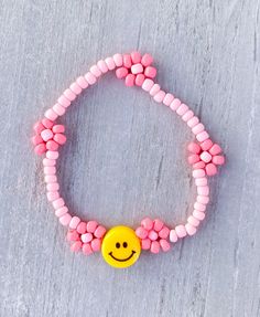 Smiley Flower Bracelet 😊😊 Made with 3mm seed beads and 8mm smiley ✨✨Customize with a name and different color, please add in Personlization Section ✨✨ CARING TIPS FOR YOUR JEWELRY ⭐️Treat and store with care. ⭐️ For longevity, avoid exposing your jewelry to water. ⭐️ Avoid having direct contact with lotions, perfumes, sanitizers as these chemicals may cause discoloration of your jewelry. Adjustable Flower Beaded Bracelet With 8mm Beads, Adjustable Flower-shaped Bracelet With Letter Beads, Cheerful Handmade Adjustable Beaded Bracelets, Cheerful Adjustable Beaded Jewelry, Smiley Face Beaded Bracelets As Gift, Adjustable Smiley Face Round Bead Bracelets, Playful Adjustable Beaded Bracelets With Flower Shape, Adjustable Friendship Bracelets With Letter Beads And Flower Shape, Playful Adjustable Flower Bracelets