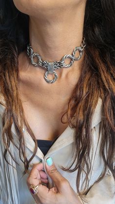 ◾ A beautiful and striking choker necklace made of silver-plated brass.    The necklace is adorned with round, twisted hoops, a foxtail chain, and a curb chain, making it suitable     For both evening and morning events. ◾   SIZE Length: 11.8IN (30cm) up to 16.5IN (42cm)       Width Hoop:  0.98IN(2.5cm).      Width curb: 0.39IN (1cm) thick chain: 0.19IN (5mm)      In addition to the length of the chain, there is an extension chain of 2.36IN (6cm) ◾   You can see a similar choker at this link:  ◾  Statement Chain Choker - Silver Choker Necklace - Thick Hoop Choker - Chunky Silver Circle      Necklace, Bold Chain O Ring Collar Necklace  ◾  The shipment is in the registered mail including a tracking number.  ◾  This piece of jewelry is perfect as a gift for yourself, for a wedding day, Valent Chunky Silver Choker, Handmade Sterling Silver Chain Choker, Adjustable Sterling Silver Choker Necklace, Silver Pendant Choker With Clavicle Chain, Silver Pendant Choker With Chain, Sterling Silver Choker With Lobster Clasp, Metal Choker With Clavicle Chain, Vintage Silver Adjustable Chain Necklace, Bohemian Silver Clavicle Chain Choker