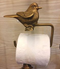 a toilet paper holder with a gold bird on it