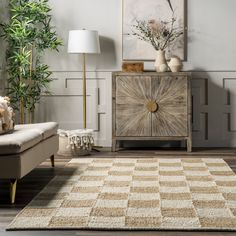 a living room with a couch, chair and rug on the floor in front of a window