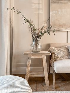 a vase filled with flowers sitting on top of a wooden table next to a couch