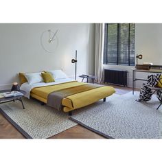 a bedroom with a yellow bed and white walls