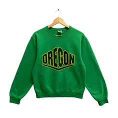 "CODE : p/260 Vintage University Oregon Green Sweatshirt Small Oregon Ducks Crewneck Oregon State Sweater Pullover University Of Oregon Ducks Print Logo  Size on Tag : S Details Measurement  Arm Pit to Arm Pit : 20\"inches Back Collar to Hem : 24\"inches Condition :  Great Vintage Condition.No Holes And No  Stain.Please refer pictures detail.‼️ 📮 SHIPING > WE ARE USING DHL EXPRESS SHIPING ITS TAKE 3-5 ARRIVE.PLEASE DROP YOUR PHONE NUMBER AFTER PURCHASE.📮" Green Cotton College Sweater, Green Varsity Long Sleeve Tops, Collegiate Green Sweatshirt For Fall, Green Long Sleeve Varsity Top, Green College Top With Ribbed Cuffs, Retro Green Top With Ribbed Cuffs, Green Collegiate Cotton Sweatshirt, Collegiate Green Cotton Sweatshirt, Green Letter Print Crew Sweater