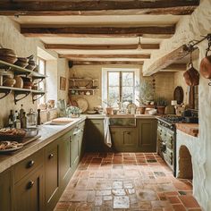 This charming English countryside kitchen showcases the beauty of earthy tones, with exposed wooden beams, terracotta floor tiles, and olive green cabinets working together to create a cozy, welcoming space Moody European Farmhouse, Countryside House Kitchen, English Country Style Kitchen, French Countryside Aesthetic Interior, European Farmhouse Kitchen, Villa Kitchen, Diy French Country Decor, French Country Kitchen Designs