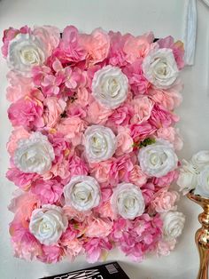 pink and white flowers are arranged on the wall