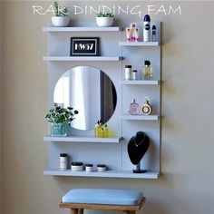 a white shelf with a mirror, vase and other items on it next to a stool