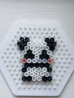 an animal made out of legos on a white surface with black and white circles